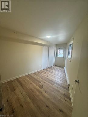 Kitchener apartment for rent - A room with wooden flooring and white walls.