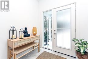 Wasaga Beach apartment for rent - A room with a wooden bench and a door leading outside.