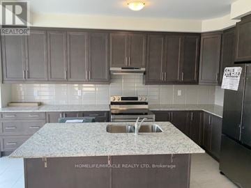 Brampton (Northwest Brampton) townhouse for rent - A kitchen with a granite countertop and a refrigerator.