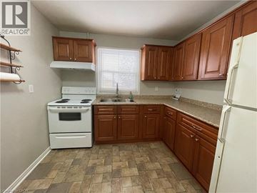 Hamilton townhouse for rent - A kitchen with brown cabinets and a white stove.