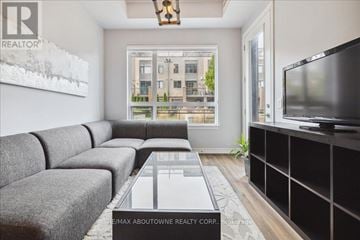 Grimsby (Grimsby Beach) townhouse for rent - A living room with a grey couch and a large window.