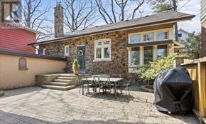 Toronto (Birchcliffe-Cliffside) apartment for rent - A patio with a table and chairs is in front of a house.