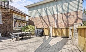 Toronto (Birchcliffe-Cliffside) apartment for rent - A backyard with a table and chairs and a fence.