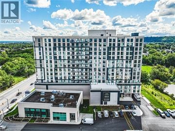 Stoney Creek apartment for rent - A large white building with a parking lot in front of it.
