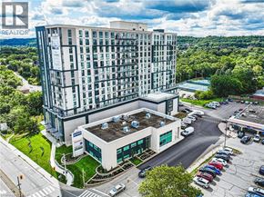 Stoney Creek apartment for rent - A large building with a parking lot in front of it.