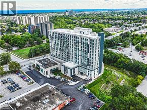 Stoney Creek apartment for rent - A large building with a parking lot in front of it.