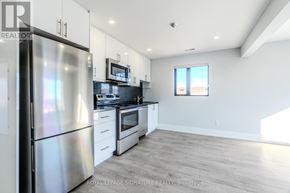 Bradford West Gwillimbury (Bradford) multi-family for rent - A kitchen with a refrigerator, stove, and microwave.