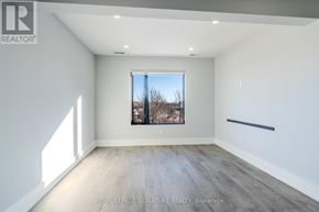 Bradford West Gwillimbury (Bradford) multi-family for rent - A spacious room with a large window and wooden flooring.