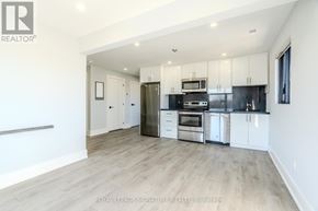 Bradford West Gwillimbury (Bradford) multi-family for rent - A spacious kitchen with white cabinets and stainless steel appliances.