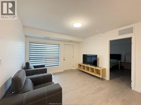 Windsor condo for rent - A window with a view of trees and a balcony.