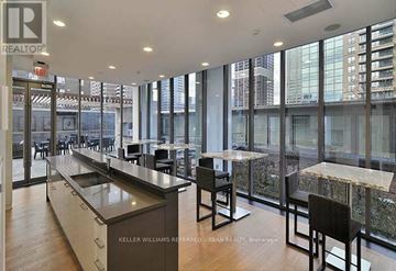 Toronto (Church-Yonge Corridor) condo for rent - A modern kitchen with a long counter and chairs.