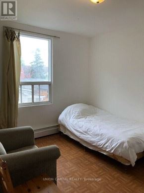 Toronto (Weston-Pellam Park) multi-family for rent - A bedroom with a bed, chair, and window.