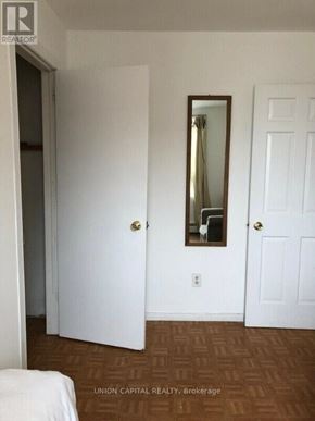 Toronto (Weston-Pellam Park) multi-family for rent - A bedroom with a bed, mirror, and two doors.