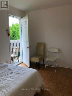 Toronto (Weston-Pellam Park) multi-family for rent - A bedroom with a bed, chair and door leading outside.