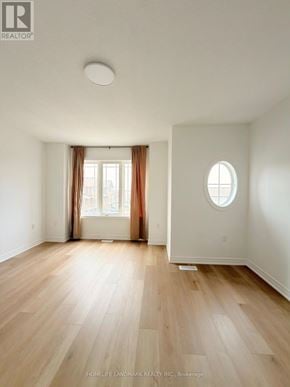 Hamilton townhouse for rent - A room with a round window and wooden flooring.