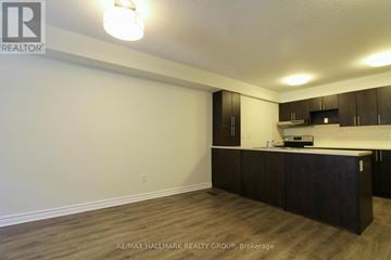 Ottawa townhouse for rent - A kitchen area with dark brown cabinets and a countertop.