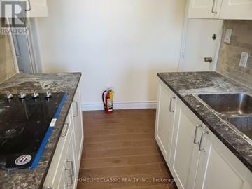 Uxbridge apartment for rent - A kitchen with white cabinets and a black counter top.