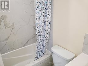 Uxbridge apartment for rent - A white toilet sits next to a bathtub in a bathroom.