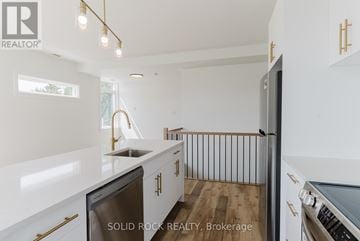 Ottawa multi-family for rent - A modern kitchen with white cabinets and a stainless steel dishwasher.