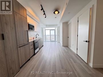 Toronto (Centennial Scarborough) condo for rent - A kitchen with wooden cabinets and a microwave above the stove.