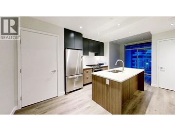 Vancouver apartment for rent - A modern kitchen with a wooden island and stainless steel appliances.