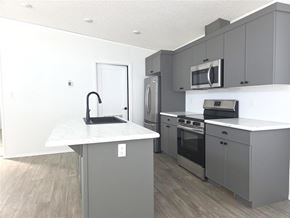 Mitchell apartment for rent - A kitchen with a white countertop and grey cabinets.
