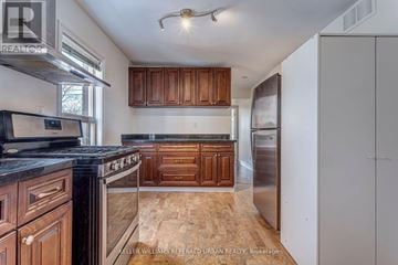 Toronto (New Toronto) apartment for rent - A kitchen with wooden cabinets and a black counter top.