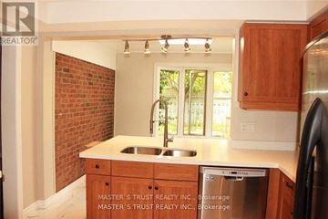 Oakville (Fd Ford) apartment for rent - A kitchen with wooden cabinets and a brick wall.