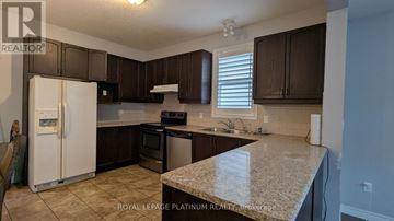 Waterloo apartment for rent - A kitchen with brown cabinets and a white refrigerator.