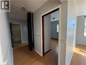 Watford apartment for rent - A room with a wooden floor and white walls, with a door open to another room.