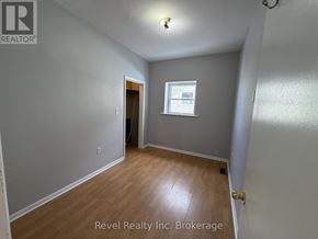 Warwick (Watford) fourplex for rent - A room with a door and a window with Revel Realty Inc. Brokerage written on the wall.