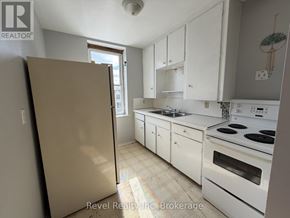Warwick (Watford) fourplex for rent - A kitchen with white cabinets and appliances.