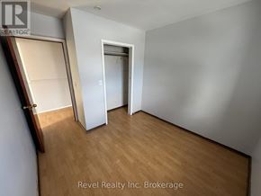 Warwick (Watford) fourplex for rent - A room with a wooden floor and a white door.