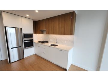 Surrey apartment for rent - A modern kitchen with white cabinets and a stainless steel refrigerator.