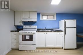 Toronto (East York) apartment for rent - A kitchen with white appliances and cabinets against a blue wall.