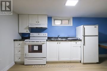Toronto (East York) apartment for rent - A kitchen with white appliances and cabinets against a blue wall.