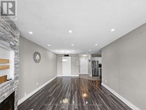 Barrie (Alliance) condo for rent - A spacious room with a stone fireplace and wood flooring.
