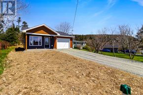 St. John's apartment for rent - A house with a garage is situated on a dirt lot.