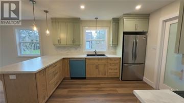 St. John's apartment for rent - A kitchen with wooden cabinets and a stainless steel refrigerator.