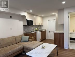 Vaughan (Vellore Village) apartment for rent - A well-lit living room with a couch, coffee table, and kitchen area in the background.