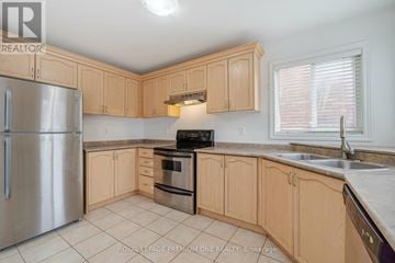 Markham (Berczy) apartment for rent - A kitchen with wooden cabinets and a stainless steel refrigerator.