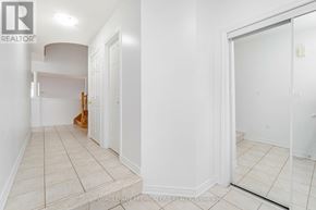Markham (Berczy) apartment for rent - A white hallway with a door on the right and a mirror on the left.