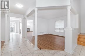 Markham (Berczy) apartment for rent - A spacious room with white walls and wooden flooring, featuring a series of white columns.