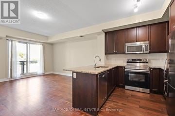 Mississauga (Erin Mills) condo for rent - A kitchen with brown cabinets and a wooden floor.