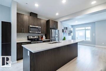 Edmonton townhouse for rent - A modern kitchen with dark wood cabinets and a white island.