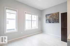 Edmonton townhouse for rent - A room with a large painting on the wall and two windows.