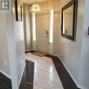 Mississauga (Central Erin Mills) apartment for rent - A hallway with a black and white tile floor and a chandelier hanging from the ceiling.
