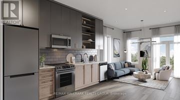 Ottawa apartment for rent - A modern kitchen with a refrigerator on the left and a living room with a couch and a coffee table on the right.