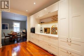 Toronto (Trinity-Bellwoods) townhouse for rent - A kitchen with white cabinets and wooden floors.
