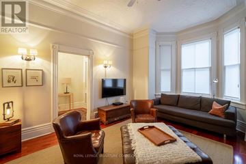 Toronto (Trinity-Bellwoods) townhouse for rent - A living room with a brown leather couch and a wooden coffee table.